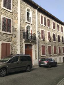 two cars parked in front of a building at La Cascade appartement F2 in Eaux-Bonnes