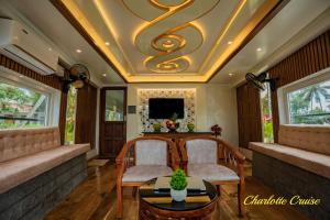 een woonkamer met 2 stoelen en een schuin plafond bij Charlotte Cruise House Boat in Alleppey