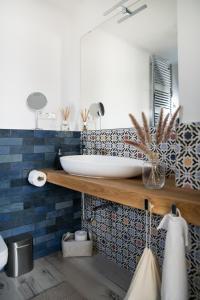 een badkamer met een wit bad en blauwe tegels bij VALONÉ Villány in Villány +7 foto's