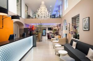 eine Lobby eines Hotels mit Sofas und einem Kronleuchter in der Unterkunft Leonardo Boutique Hotel Linz City Center in Linz