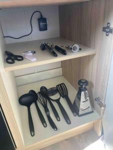 a wooden cabinet with utensils on a shelf at Luxuary Static Caravan Sleeps 6 Coopers Beach - Luxurious Get Away in East Mersea