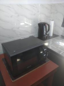 a black coffee maker sitting on top of a microwave at Chinaka guest house in Lagos