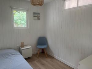 - une chambre avec un lit et une chaise bleue dans l'établissement Biscarrosse Lac - Maguide -Modern Chalet, à Biscarrosse