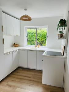 uma cozinha branca com um lavatório e uma janela em Biscarrosse Lac - Maguide -Modern Chalet em Biscarrosse