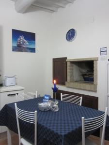 a kitchen with a blue table with chairs and a clock at LE GEMME DI PERUGIA - alloggi in centro storico - VIA DELLA CUPA / VIA DELIZIOSA in Perugia