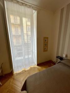 a bedroom with a bed and a large window at La Casa di Titilla in Turin