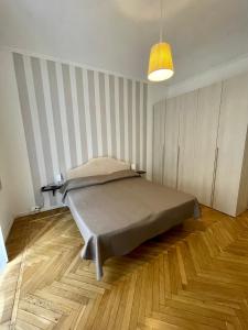 a bedroom with a bed with a striped wall at La Casa di Titilla in Turin