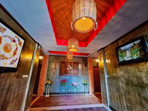 โรงแรมเชียงใหม่ล้านนา & โมเดิร์นลอฟท์ (Chiangmai Lanna Modern Loft Hotel) في سان كامبينغْ: ممر بسقف احمر وطاولة بالورود
