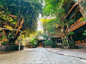 โรงแรมเชียงใหม่ล้านนา & โมเดิร์นลอฟท์ (Chiangmai Lanna Modern Loft Hotel) في سان كامبينغْ: فناء به اشجار وطريق حجري