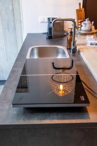a kitchen counter with a sink with a candle at Thús yn Hantum in Hantum