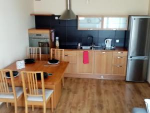 a kitchen with a wooden table and a refrigerator at Apartment Inter Trade fair Poznan in Poznań