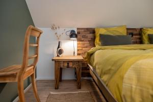 ein Schlafzimmer mit einem Bett und einem Tisch mit einem Stuhl in der Unterkunft B&B Thús yn Hantum in Hantum