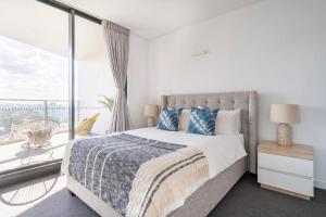 a bedroom with a bed and a large window at The Occidental Pearl in Sydney
