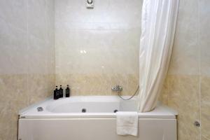 W łazience znajduje się wanna z zasłoną prysznicową. w obiekcie AEROPORTO - FIERA DI ROMA Oasi di relax vicino il treno con self check-in w mieście Porto