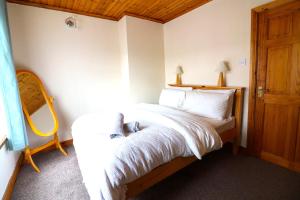 a bedroom with a bed with white sheets and a mirror at St James's Rd in Belfast