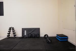 a room with a white wall and a gym with equipment at Hotel Sol Nascente in Arapiraca