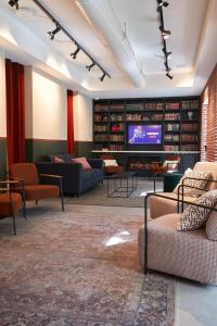 uma grande sala de estar com sofás e uma televisão em LATROUPE Prado Hostel em Madri