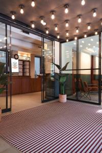 a lobby with a potted plant on a rug at LATROUPE Prado Hostel in Madrid