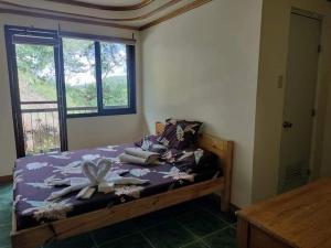 1 dormitorio con 1 cama con toallas en Trekkers Lodge and Cafe, en Banaue