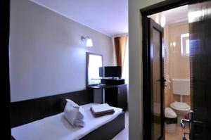 a hotel room with a bed and a bathroom at Calla Inn Hotel in Constanţa