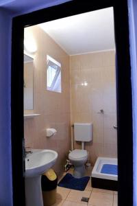 a bathroom with a toilet and a sink and a tub at Calla Inn Hotel in Constanţa