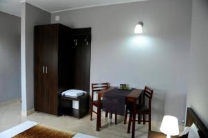 a dining room with a table and chairs and a cabinet at Calla Inn Hotel in Constanţa