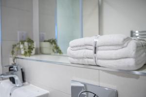 uma pilha de toalhas num balcão na casa de banho em Cosy 3 Bed by Old Trafford By Valore Property Services em Manchester
