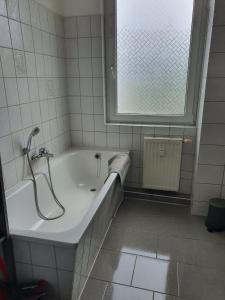 baño con bañera y ventana en Mimalou möbliertes Apartment in Crimmitschau, en Crimmitschau