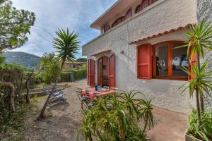 Casa con puerta roja y patio en Casa Palmaiola, en Cavo