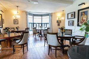 a restaurant with tables and chairs in a room at Tickton Grange Hotel in Beverley