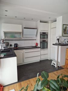 a white kitchen with white cabinets and appliances at Hochwertige 85qm-Wohnung in Wuppertal-Vohwinkel in Wuppertal