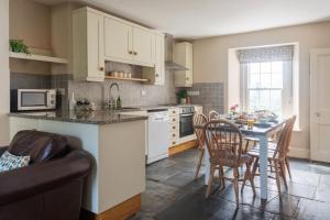 uma cozinha com mesa e cadeiras e uma sala de jantar em Rosehip Cottage em Holbeton