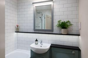 a bathroom with a sink and a mirror at Rosehip Cottage in Holbeton