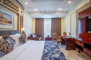 a hotel room with a bed and a desk at The Avenue Grand in Calangute