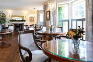 a dining room with tables and chairs and a fireplace at Tickton Grange Hotel in Beverley