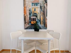 a white table with chairs and a picture of a tram at Apartments with Garden in Bad Vilbel