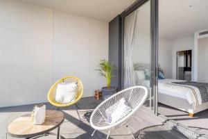 a bedroom with two chairs and a bed and a table at The Occidental Pearl in Sydney