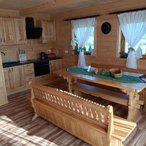a kitchen with a table and a bench in a cabin at Domek na farmie in Szaflary