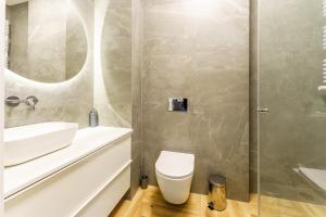 a bathroom with a toilet and a sink and a shower at Apartament Granitowy Ku Morzu by HolidaySun in Sianozety