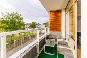 a balcony with a table and chairs at Apartament Granitowy Ku Morzu by HolidaySun in Sianozety