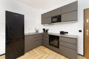 a kitchen with a black refrigerator and a microwave at Apartament Granitowy Ku Morzu by HolidaySun in Sianozety