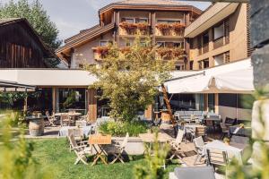 een patio met tafels en stoelen voor een gebouw bij Hotel Restaurant Langgenhof in Brunico
