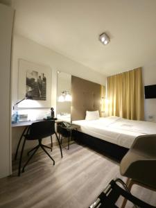 a hotel room with a bed and a desk at Hotel Amadeus in Hannover