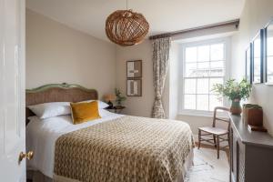 a bedroom with a bed and a window at Wild Rose Cottage in Holbeton