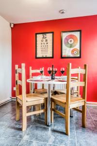 a dining room with a red wall and a table and chairs at Pangbourne House in Higham on the Hill