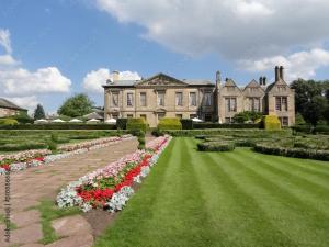 a large house with a garden of flowers in front of it at Pangbourne House in Higham on the Hill