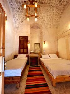 a bedroom with two beds and a chandelier at Taşkıran Hotel in Urfa +4 photos