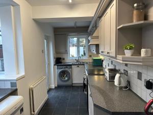 a kitchen with a washer and a washing machine at Family-Friendly 4BR Home in Sale, Manchester - Garden & Double Driveway in Sale