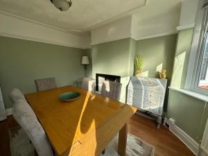 a dining room with a wooden table and chairs at Stylish & Homely 3 BR House in Sale