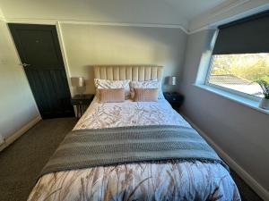 a bedroom with a large bed with a window at Stylish & Homely 3 BR House in Sale